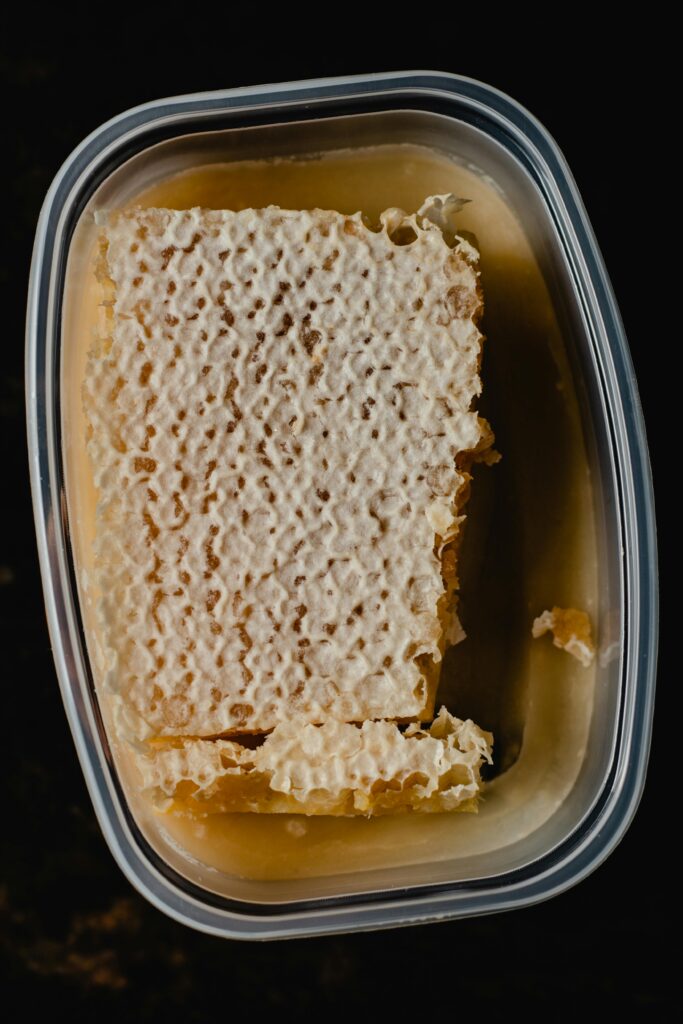 Top view of a fresh honeycomb in a plastic container, sweet and nutritious.